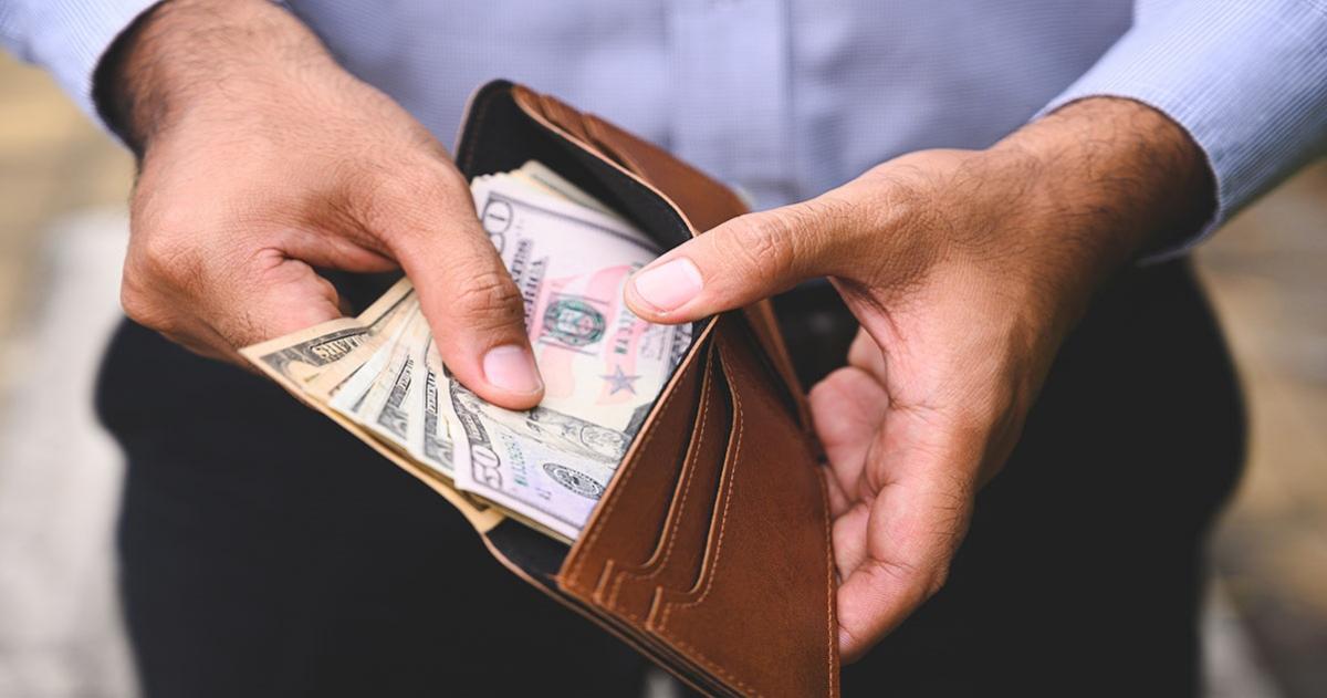 Person holding wallet showing cash