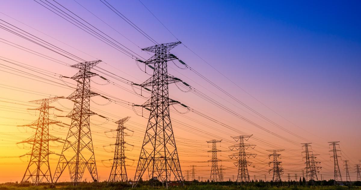 Image of power lines with a sunset in the background