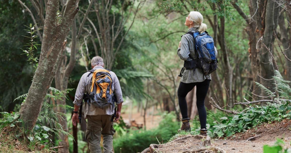 Older woman and man hiking in the woods