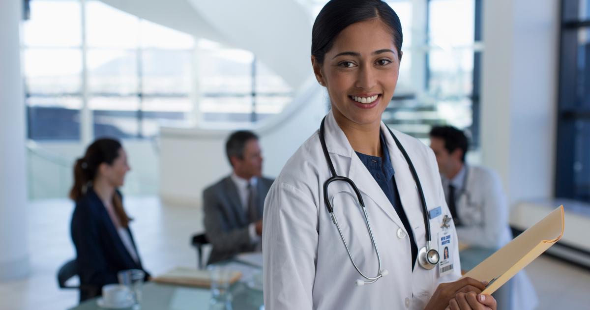 Young female physician in a hospital smiling at camera