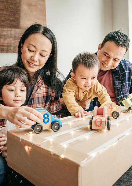 Family enjoying time with their children playing with toy cars