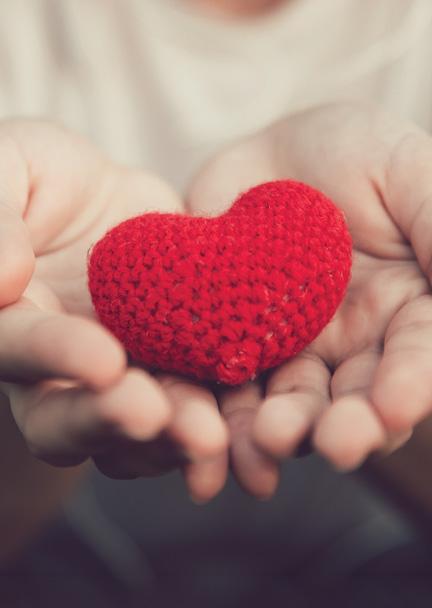 Close up of hands holding crochet heart